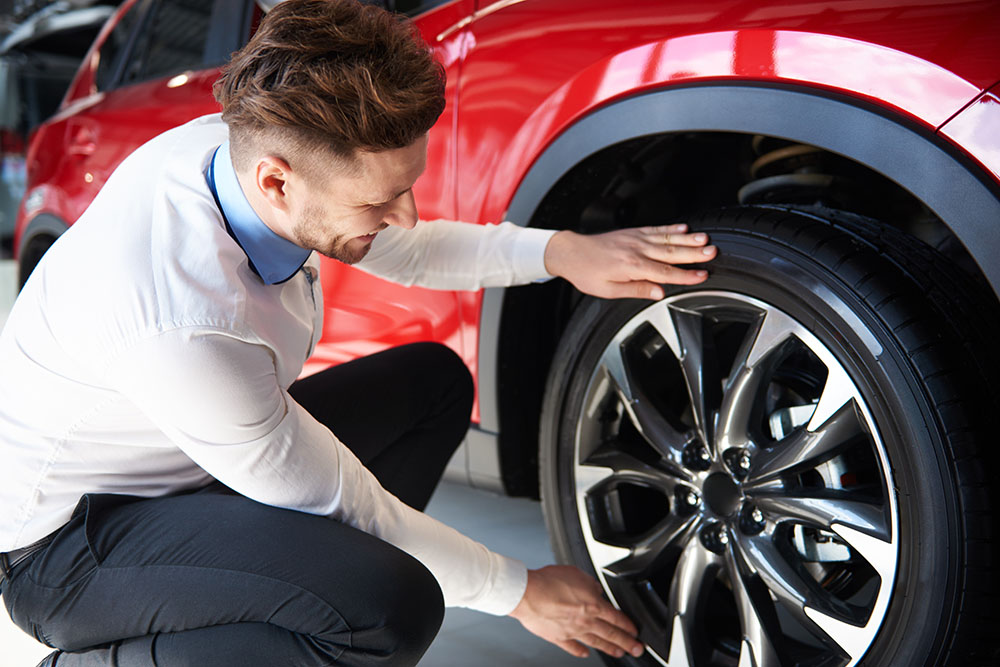 Verkäufer-überprüft-Felgen-rotes-Auto